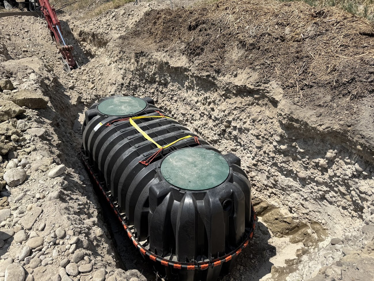 Two-compartment septic tank set and plumbed into the trench